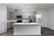 Modern kitchen featuring stainless steel appliances, gray cabinets, an island, and wood-look flooring at 817 Cottonwood Hill Pl, Henderson, NV 89011