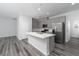 A modern kitchen with stainless steel appliances, gray cabinets, a large island, and hardwood floors at 817 Cottonwood Hill Pl, Henderson, NV 89011
