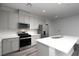 Modern kitchen featuring stainless steel appliances, gray cabinets, an island, and wood-look flooring at 817 Cottonwood Hill Pl, Henderson, NV 89011