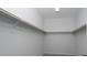 A walk-in closet featuring white walls, neutral carpet, and wooden closet rods for ample storage at 817 Cottonwood Hill Pl, Henderson, NV 89011