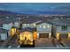 Aerial view of a well-lit home with a tile roof, brick driveway, and manicured landscaping at twilight at 8984 Rolling Pietra St, Las Vegas, NV 89166