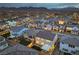 Expansive aerial view of a well-lit residential community with mountain views and modern home exteriors at 8984 Rolling Pietra St, Las Vegas, NV 89166
