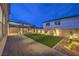 Spacious backyard with artificial turf, stone landscaping, a covered patio, and outdoor lighting, perfect for entertaining at 8984 Rolling Pietra St, Las Vegas, NV 89166