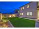 Landscaped backyard featuring artificial turf, decorative stone, and exterior lighting, creating a serene outdoor space at 8984 Rolling Pietra St, Las Vegas, NV 89166
