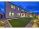 Landscaped backyard offers outdoor living with turf, stone, and lighting extending the home's space at 8984 Rolling Pietra St, Las Vegas, NV 89166