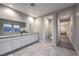 Bathroom with dual sinks and a view leading to a hallway and toilet area at 8984 Rolling Pietra St, Las Vegas, NV 89166