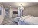 Elegant bedroom features a modern chandelier, neutral tones, and a cozy chaise lounge at 8984 Rolling Pietra St, Las Vegas, NV 89166
