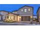 Two-story home featuring a stucco exterior, a two-car garage, and a well-maintained front yard with landscape lighting at 8984 Rolling Pietra St, Las Vegas, NV 89166