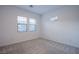 Bright bedroom with neutral carpet and natural light from two windows overlooking the backyard stone wall at 909 Allister Fields Ln, Las Vegas, NV 89138