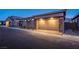 View of garage featuring stacked stone accents, coach lights, and brick pavers on the driveway at 909 Allister Fields Ln, Las Vegas, NV 89138