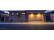 Modern home showcasing a large, well-lit garage with stone accents, a paved driveway, and desert landscaping at 909 Allister Fields Ln, Las Vegas, NV 89138