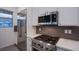 Updated kitchen featuring stainless steel appliances, white cabinets, modern tile backsplash and tile floors at 909 Allister Fields Ln, Las Vegas, NV 89138
