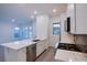 Open kitchen area featuring stainless steel appliances, white cabinets, a spacious island, and tile flooring at 909 Allister Fields Ln, Las Vegas, NV 89138