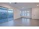 Bright living room with neutral palette, features tile flooring, large windows and sliding glass door at 909 Allister Fields Ln, Las Vegas, NV 89138