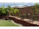 Landscaped backyard featuring mature trees, brick retaining wall, and partial synthetic turf at 9205 Valley Betica Ave, Las Vegas, NV 89148
