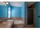 Bathroom showcasing blue walls, a single sink, a bathtub and a tile shower at 9449 Amber Valley Ln, Las Vegas, NV 89134