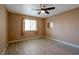 A bedroom with new light gray wood floors, ceiling fan, and neutral colored walls and window at 9449 Amber Valley Ln, Las Vegas, NV 89134