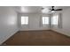 A bedroom featuring two windows, neutral carpet, a ceiling fan, and white walls at 9449 Amber Valley Ln, Las Vegas, NV 89134