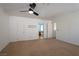 Spacious bedroom featuring neutral carpet, ceiling fan, access to bathroom and a walk in closet at 9449 Amber Valley Ln, Las Vegas, NV 89134
