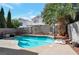 Backyard oasis featuring a sparkling pool, lush landscaping, and a private setting perfect for outdoor enjoyment at 9449 Amber Valley Ln, Las Vegas, NV 89134