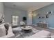 Bright and airy living room featuring stylish furniture, floating shelves, modern décor and a large window at 950 Marbelwood Ave, Las Vegas, NV 89123