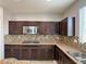 This kitchen features dark wood cabinets, stainless steel appliances, granite countertops, and tile backsplash at 9604 Vital Crest St, Las Vegas, NV 89123