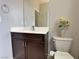 Clean powder room showcasing dark wood vanity, white sink, and decorative accents at 9604 Vital Crest St, Las Vegas, NV 89123