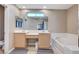 Bright bathroom with double sinks, large mirror, soaking tub and tile flooring at 967 Coronado Peak Ave, Las Vegas, NV 89183