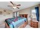 Comfortable bedroom with wooden bed frame, ceiling fan and natural light from the window at 967 Coronado Peak Ave, Las Vegas, NV 89183
