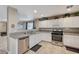 Bright kitchen showcasing tile floors, white cabinets, and stainless steel dishwasher and oven at 967 Coronado Peak Ave, Las Vegas, NV 89183