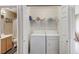 A white stacked washer and dryer are visible in the laundry closet with shelf storage above and bi-fold doors at 967 Coronado Peak Ave, Las Vegas, NV 89183