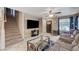 Spacious living room featuring tile flooring, access to stairs, and a large TV at 967 Coronado Peak Ave, Las Vegas, NV 89183