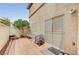 A tiled backyard patio featuring a patio table with two chairs and sliding glass door near a fenced garden bed at 967 Coronado Peak Ave, Las Vegas, NV 89183