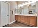 Bathroom vanity featuring double sinks, wood cabinets, and a large mirror at 9746 Vista Cache Ct, Las Vegas, NV 89148