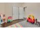 Bedroom features wood floors, play area, walk-in closet, and neutral wall colors at 9746 Vista Cache Ct, Las Vegas, NV 89148