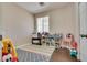 Bedroom with wood floors, large window for natural light, and play area with colorful decor at 9746 Vista Cache Ct, Las Vegas, NV 89148