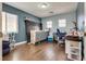 Bedroom features hardwood floors, dual pane windows, and blue accent wall at 9746 Vista Cache Ct, Las Vegas, NV 89148