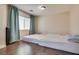 Bedroom with wood floors, two beds, window with blinds, and teal drapes at 9746 Vista Cache Ct, Las Vegas, NV 89148