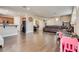 Spacious living room featuring wood-look floors, a large leather couch, and plenty of natural light at 9746 Vista Cache Ct, Las Vegas, NV 89148