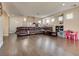 Open-concept living room with wood-look floors, a large sectional couch, and access to a dining area at 9746 Vista Cache Ct, Las Vegas, NV 89148