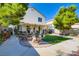 A backyard patio area with dining set, lush lawn, mature landscaping, and mature trees at 10413 Rising Harbor Ave, Las Vegas, NV 89129