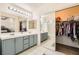 Bathroom features dual sinks, large mirrors, bright lights, and a closet offering extra space and convenience at 10413 Rising Harbor Ave, Las Vegas, NV 89129