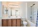 Bathroom featuring dual sinks, a shower and tub, bright lighting, and neutral tones for a serene atmosphere at 10413 Rising Harbor Ave, Las Vegas, NV 89129