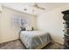 Small bedroom features neutral tones, ceiling fan, and window for a simple and comfortable living space at 10413 Rising Harbor Ave, Las Vegas, NV 89129