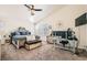 Bedroom features a king bed, modern decor, ceiling fan, window, and desk for a work or relaxation space at 10413 Rising Harbor Ave, Las Vegas, NV 89129