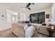 Cozy living room featuring neutral paint, carpet, ceiling fan and custom built-in shelving unit at 10413 Rising Harbor Ave, Las Vegas, NV 89129