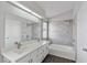 Bathroom featuring dual sinks, a shower-tub combo, a large mirror, and ample lighting at 120 Wynntry Dr, Henderson, NV 89074