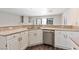 Kitchen with white cabinets, stone countertops, stainless steel dishwasher, and wood floors at 120 Wynntry Dr, Henderson, NV 89074