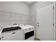 Laundry room featuring modern washer and dryer, with storage shelves, and convenient access door at 121 Staplehurst Ave, Henderson, NV 89002
