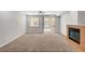 Open-concept living room features a fireplace, neutral tones, and a sliding glass door to the patio at 121 Staplehurst Ave, Henderson, NV 89002